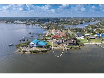 Stunning aerial view of waterfront property with lush landscaping and private dock at 5912 Riverview Ln, Bradenton, FL 34209
