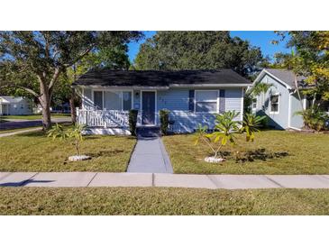 Charming light blue single-story home featuring a well-manicured lawn and inviting front porch at 777 51St N Ave, St Petersburg, FL 33703