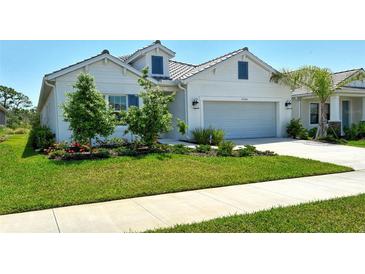 Charming one-story home boasts a well-manicured lawn, lush landscaping, and a neutral exterior color palette at 10186 Crystal Isle Cir, Sarasota, FL 34241
