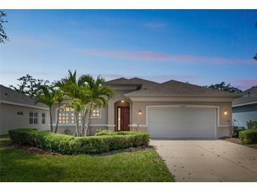Charming single-story home with a well-manicured lawn, mature landscaping, and a two-car garage at 12642 Cara Cara Loop, Bradenton, FL 34212