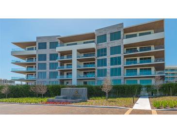 Luxury condo building with multiple floors, large windows, and private balconies with glass railings at 1591 Gulf Of Mexico Dr # 511, Longboat Key, FL 34228