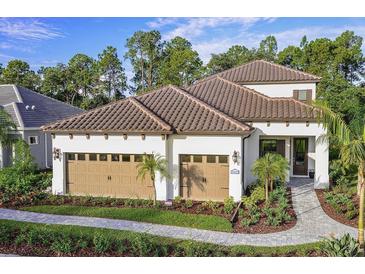 Charming single-story home boasting a tile roof, three-car garage, and lush landscaping at 21225 Wacissa Dr, Venice, FL 34293