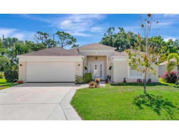 Charming single-story home with a well-manicured lawn, attached garage, and inviting front entrance at 230 Fareham Dr, Venice, FL 34293