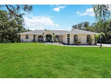Charming single-story home with a lush green lawn and eye-catching architectural details at 296 Pine Ranch Trl, Osprey, FL 34229