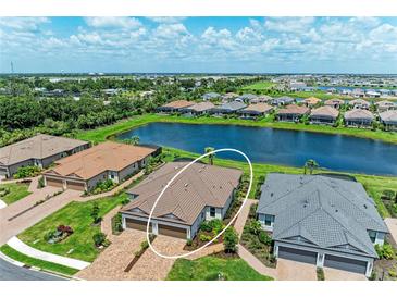 Beautiful aerial view of home with pond, lush landscaping and tile roof in a desirable community at 3027 Formia Ct, Lakewood Ranch, FL 34211