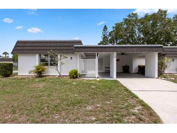 Charming single-story home with covered parking and landscaped front yard on a sunny day at 3978 Overlook Bend Ter # 25, Sarasota, FL 34232
