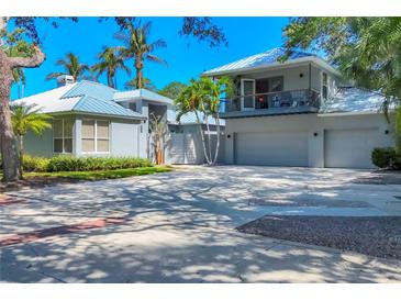 Stunning two-story home with a balcony, spacious garage and lush tropical landscaping at 4505 Camino Real, Sarasota, FL 34231