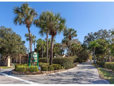 A community entrance featuring mature palms and lush landscaping welcomes visitors to Village Gardens at 4869 Village Gardens Dr # 189, Sarasota, FL 34234