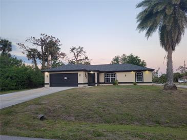 Charming single-story home featuring a two-car garage and well-manicured lawn at 5482 Globe Ter, North Port, FL 34286