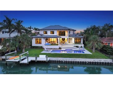 Stunning waterfront home featuring a private dock, sparkling pool, and lush landscaping at 612 Mourning Dove Dr, Sarasota, FL 34236