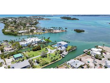 Stunning aerial view of coastal homes, showcasing turquoise waters and lush landscaping, perfect for waterfront living at 630 De Narvaez Dr, Longboat Key, FL 34228