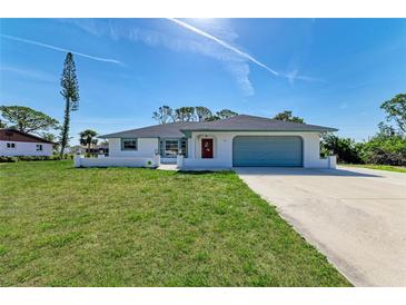 Charming one-story home with a well-maintained lawn, blue trim, red door and attached garage at 645 Liberty St, Englewood, FL 34223