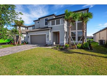 Beautiful two-story home featuring a manicured lawn, attached two-car garage, and lovely landscaping at 7533 Nighthawk Drive, Sarasota, FL 34241