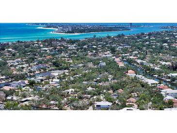Breathtaking aerial view of a waterfront community with lush greenery and turquoise waters at 755 Edgemere Ln, Sarasota, FL 34242