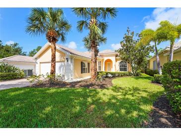 Charming single-story home featuring a tile roof, lush landscaping, and mature palm trees in a well-maintained front yard at 7716 Uliva Way, Sarasota, FL 34238