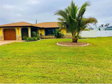 Charming yellow home with a well-manicured lawn and a decorative palm tree in the front yard at 9089 Berendo Ave, Englewood, FL 34224
