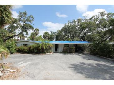Charming single-story home with a carport and lush landscaping at 129 Pierson Ln, Sarasota, FL 34242