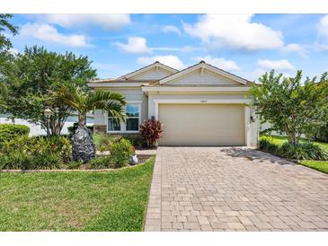 Charming single-Gathering home features a manicured lawn, brick driveway, and attached two-car garage at 13819 American Prairie Pl, Bradenton, FL 34211