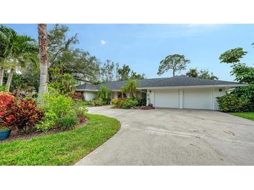 Sprawling home exterior featuring lush landscaping, a long driveway, and a two car garage at 1610 S Orange Ave, Sarasota, FL 34239