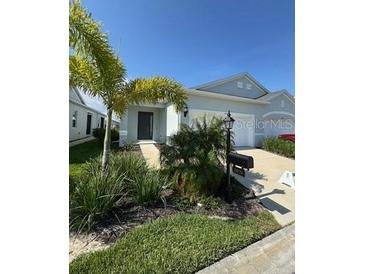 Charming single-story home with well-maintained landscaping and a welcoming front entrance at 24779 Buckingham Way, Port Charlotte, FL 33980