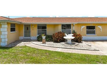 Inviting single-story home featuring a well-maintained front yard and dolphin statues at 264 E Tarpon Nw Blvd, Port Charlotte, FL 33952