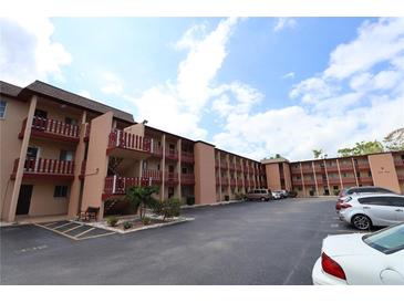 Exterior shot of the condo building with parking, featuring multiple levels and balconies at 4154 Heron Way # 203B, Bradenton, FL 34205