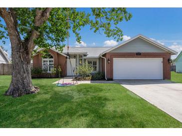 Charming single-story brick home featuring a well-manicured lawn and mature shade tree with a swing at 613 E 49Th E St, Bradenton, FL 34208