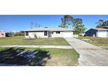 Charming single-story home with a well-manicured lawn and a concrete driveway at 7524 Kavanda St, North Port, FL 34287