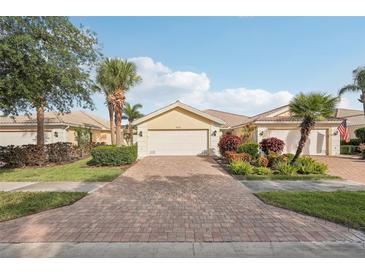 Inviting single-story home featuring a brick driveway and lush, tropical landscaping at 7632 Quinto Dr, Sarasota, FL 34238