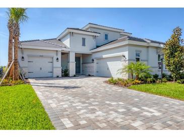 Beautiful two-story home featuring a three-car garage, stone accents, and professionally landscaped yard at 17122 Ranchside Pl, Bradenton, FL 34211