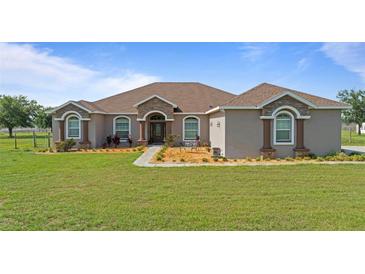 Stunning single-story home with stone accents, well-manicured lawn, and meticulous landscaping at 2350 Virgil Hall Rd, Lithia, FL 33547