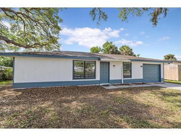 Charming single-story home featuring a white exterior, blue trim, and a well-maintained front yard at 400 E Baffin Dr, Venice, FL 34293