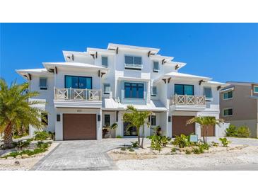 Stunning modern white townhouse with beautiful landscaping and a paver driveway at 401 39Th St, Holmes Beach, FL 34217