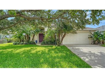 Charming home featuring a lush green lawn, mature trees, and a neatly landscaped front yard at 5044 Creekside Trl, Sarasota, FL 34243