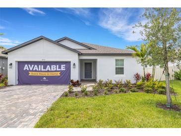 Charming single-story home featuring manicured landscaping and a welcoming front entrance, ready for quick move-in at 5213 Patano Loop, Palmetto, FL 34221
