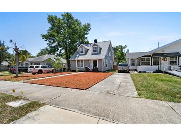 Charming two-story home with a gray exterior, manicured lawn, and a long driveway at 766 13Th S Ave, St Petersburg, FL 33701