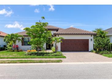 Charming one-story home with a tile roof, brick driveway, well manicured lawn, and attached two car garage at 8020 Clearwater Ct, Sarasota, FL 34241