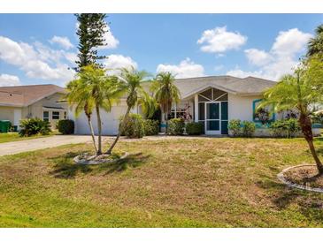 Charming single-story home with well-manicured lawn and tropical landscaping at 1304 Alton Rd, Port Charlotte, FL 33952