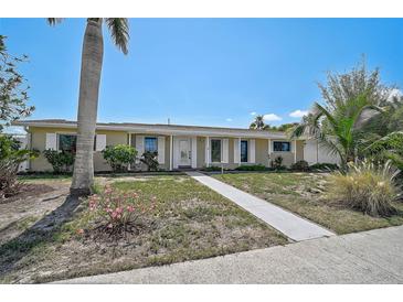Charming single-story home featuring a well-manicured lawn, inviting walkway, and beautiful landscaping at 149 Small Se St, Port Charlotte, FL 33952