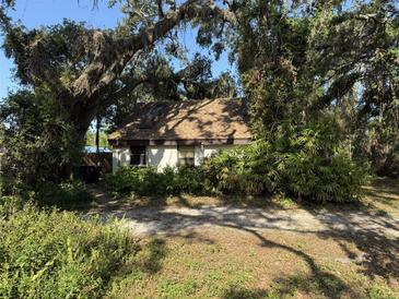 Cozy single-story home nestled among mature trees, offering a serene and private setting at 1511 11Th W Ave, Palmetto, FL 34221