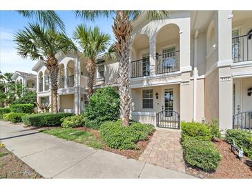 Townhouse exterior with lush landscaping, multiple balconies, and Mediterranean style architecture at 1519 Napoli E Dr, Sarasota, FL 34232
