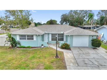 Lovely single-story home showcasing a tidy front yard, long driveway, and an attached garage at 1801 Forest Dr, Oldsmar, FL 34677