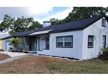Charming single-story home showcasing a white exterior, complemented by a well-maintained yard and dark roof at 1802 19Th W Ave, Bradenton, FL 34205