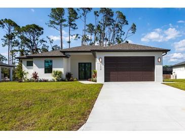 Charming single-story home featuring a manicured lawn, neutral paint scheme, and an attached two-car garage at 2638 Hagerick Ln, North Port, FL 34288