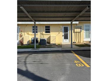 Exterior shot featuring covered parking and well-maintained landscaping at 6006 Midnight Pass Rd # 48, Sarasota, FL 34242