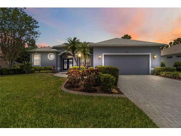 Charming one-story home featuring a well-manicured lawn, beautiful landscaping, and an attached two-car garage at 664 Planters Manor Way, Bradenton, FL 34212