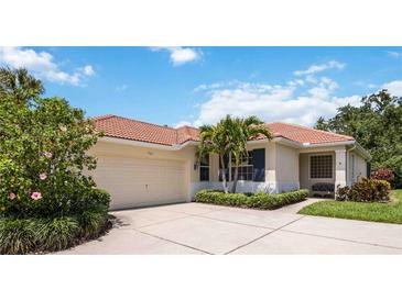 Charming single-story home boasts a red tile roof, manicured landscaping, and a two-car garage at 706 Misty Pond Ct, Bradenton, FL 34212