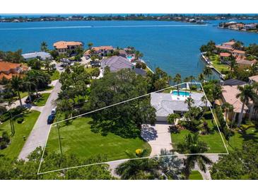 Waterfront estate with lush landscaping, a private pool, and stunning views of the bay at 7614 Peninsular Dr, Sarasota, FL 34231