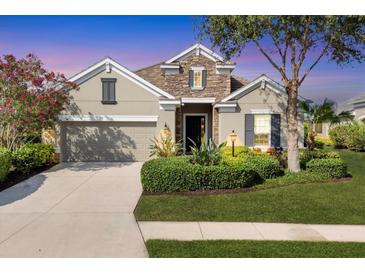Charming home with stone accents, lush landscaping, and a well-manicured front lawn at 12908 Crystal Clear Pl, Bradenton, FL 34211
