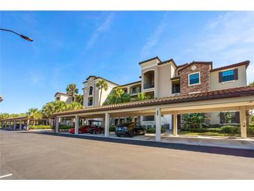 Multi-story condo with covered parking featuring stone accents and lush landscaping at 17118 Vardon Ter # 404, Bradenton, FL 34211